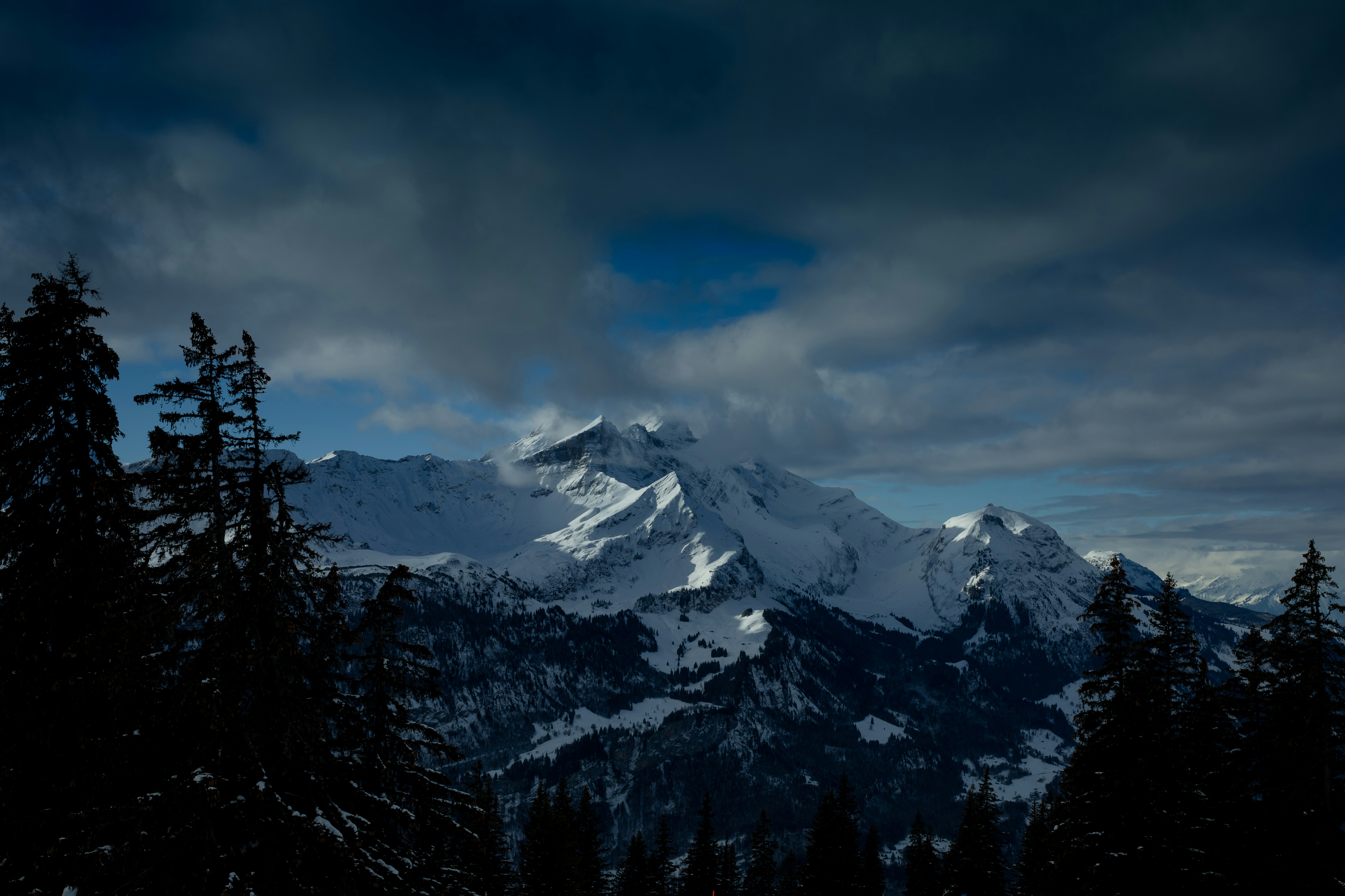 snow covered mountain under cloudy sky during daytime